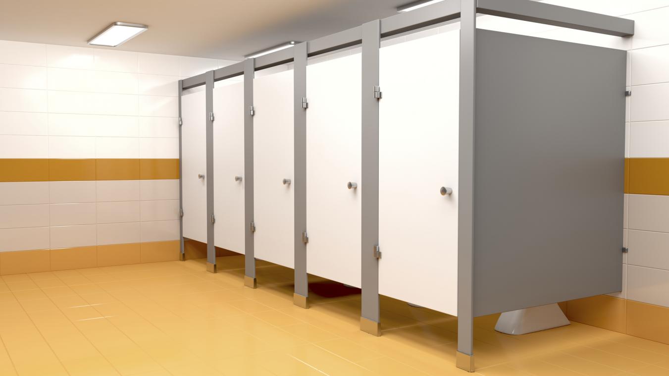 Personne jetant un coup d'œil sous une porte de toilettes pour vérifier si la cabine est occupée