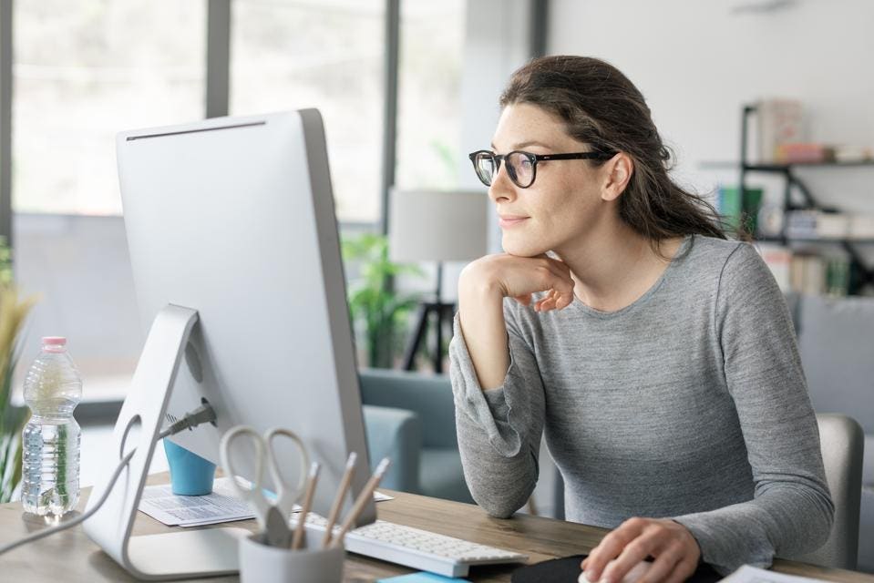 Femme souriante travaillant sur son ordinateur portable dans un café