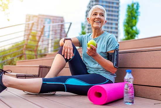 Femme souriante de plus de 50 ans faisant du sport en tenue de fitness