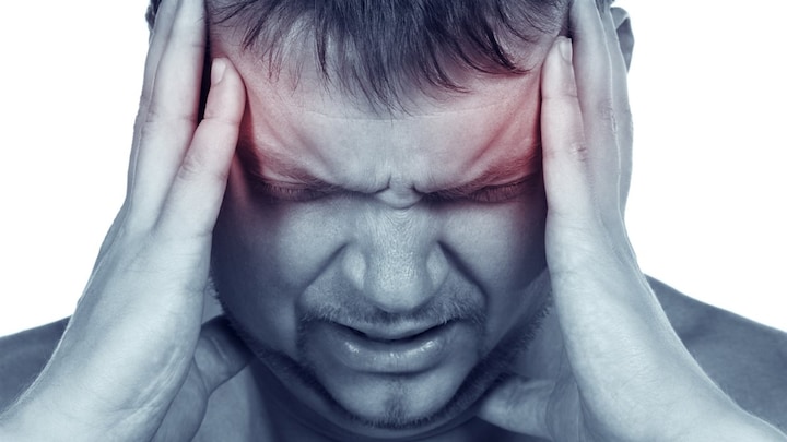 Femme pressant ses tempes pour soulager un mal de tête