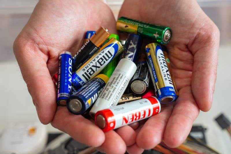 Mains tenant plusieurs piles usagées de différentes tailles