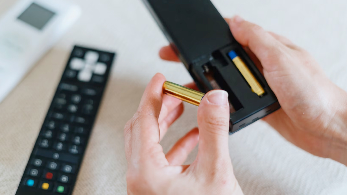 Piles alignées à côté d'une télécommande