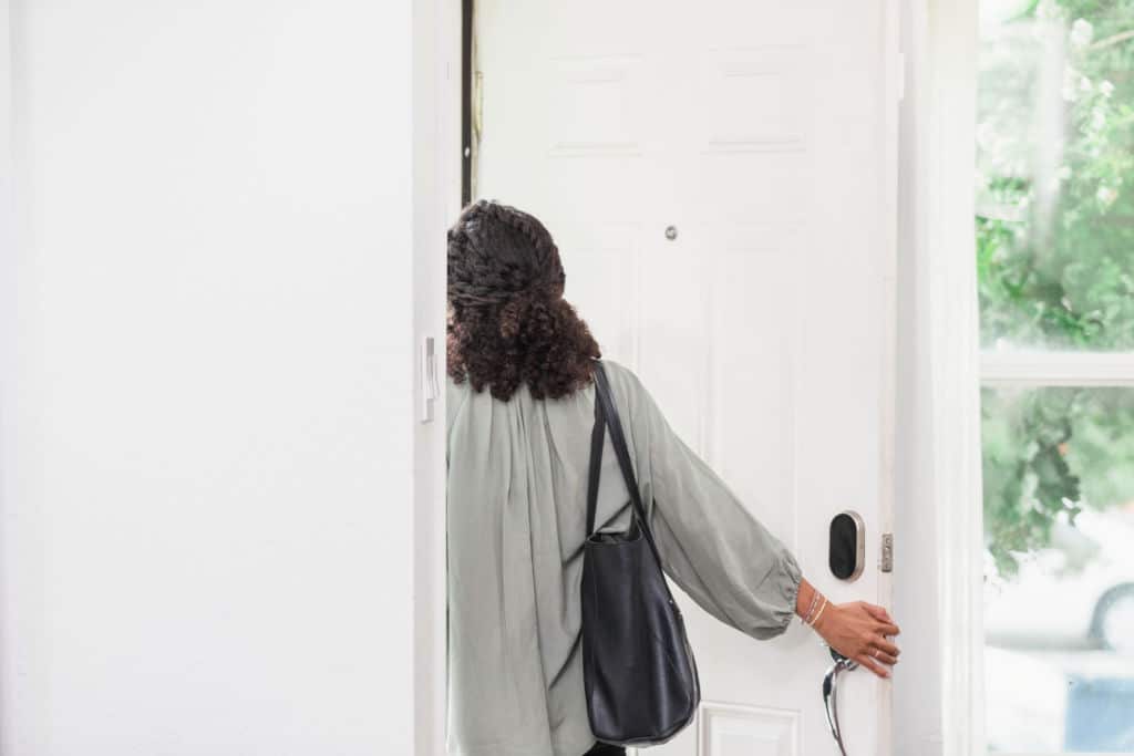 Femme quittant une maison pensive